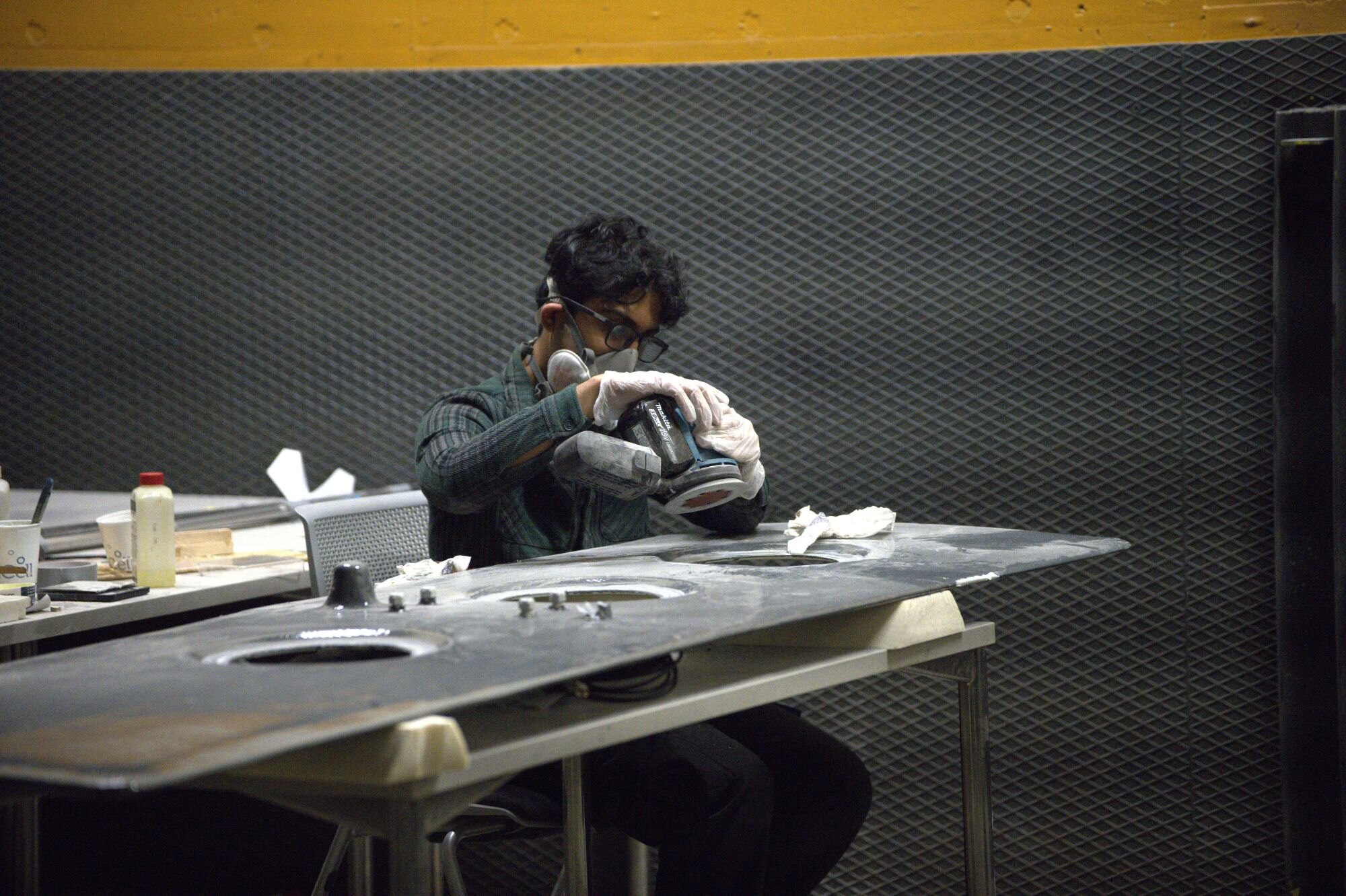 A team member sanding the deck of our boat in the workshop