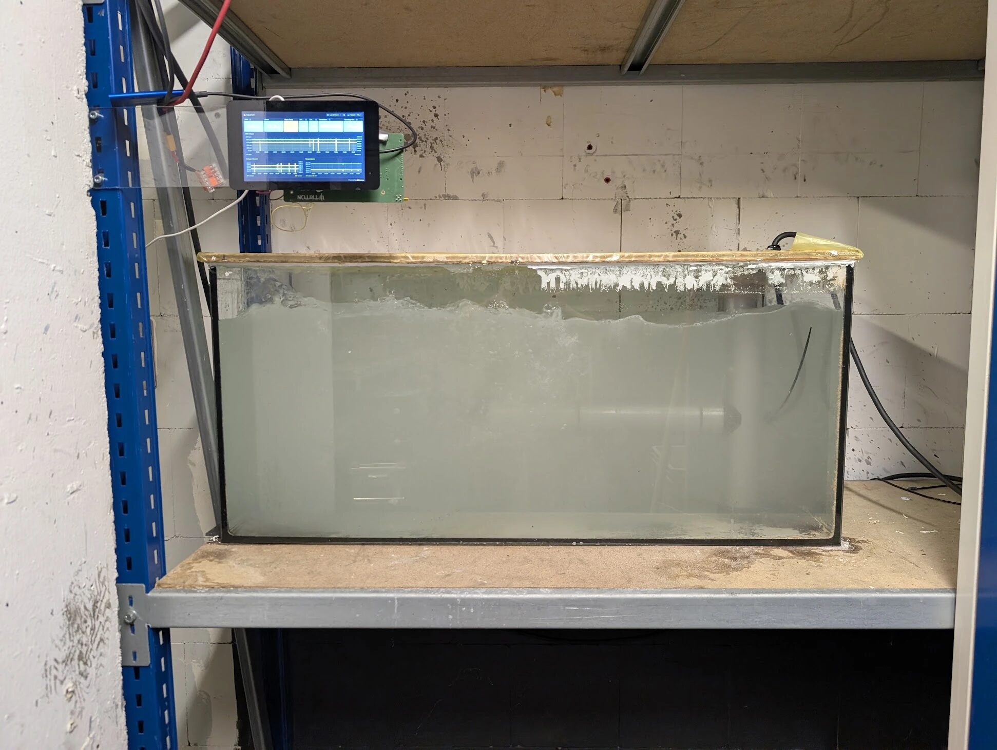 The thruster in the saltwater test tank, with the live data display above it